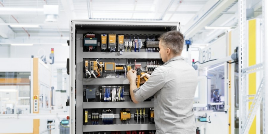 Henkilö tutkimassa virtakiskokomponentteja